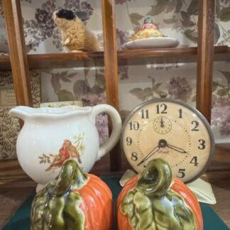 Pumpkin-shaped containers, white pitcher with bird design, and clock